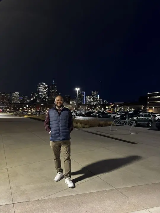 Johnson outside at night, a city skyline behind him
