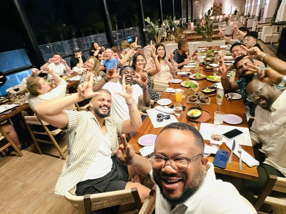 A team dinner, everyone cheering for the camera