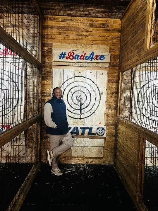 Johnson in an axe throwing lane, his axe in the target