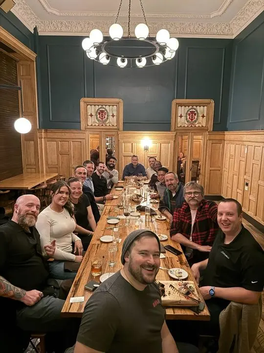 A long team dinner in a wood-panelled room